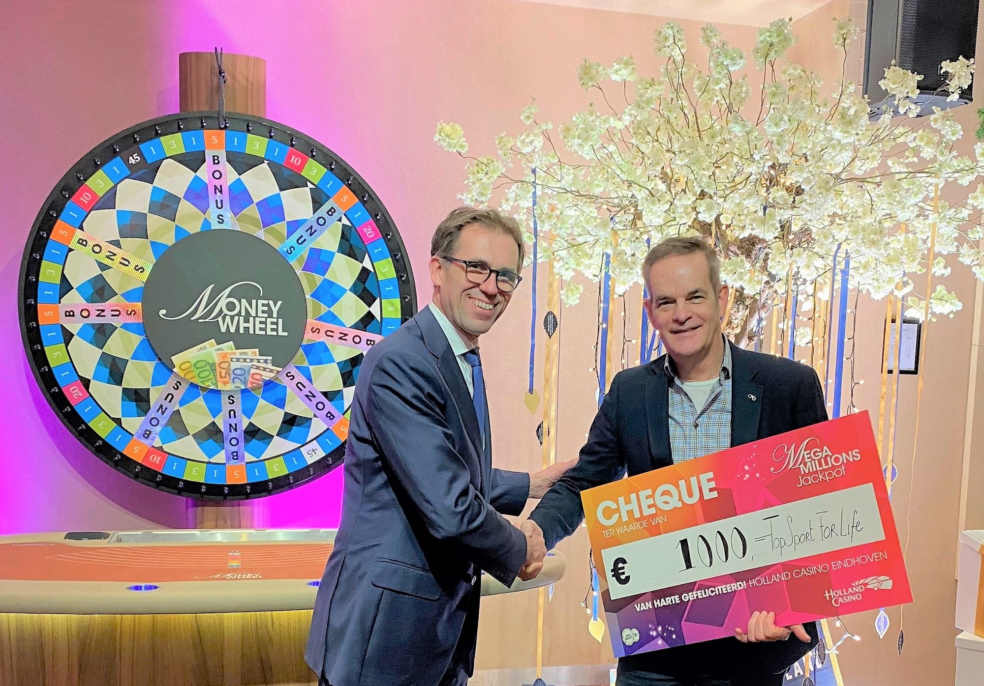Hans van Heteren, links op de foto,  overhandigt cheque aan Miel in 't Zand van Topsport for Life