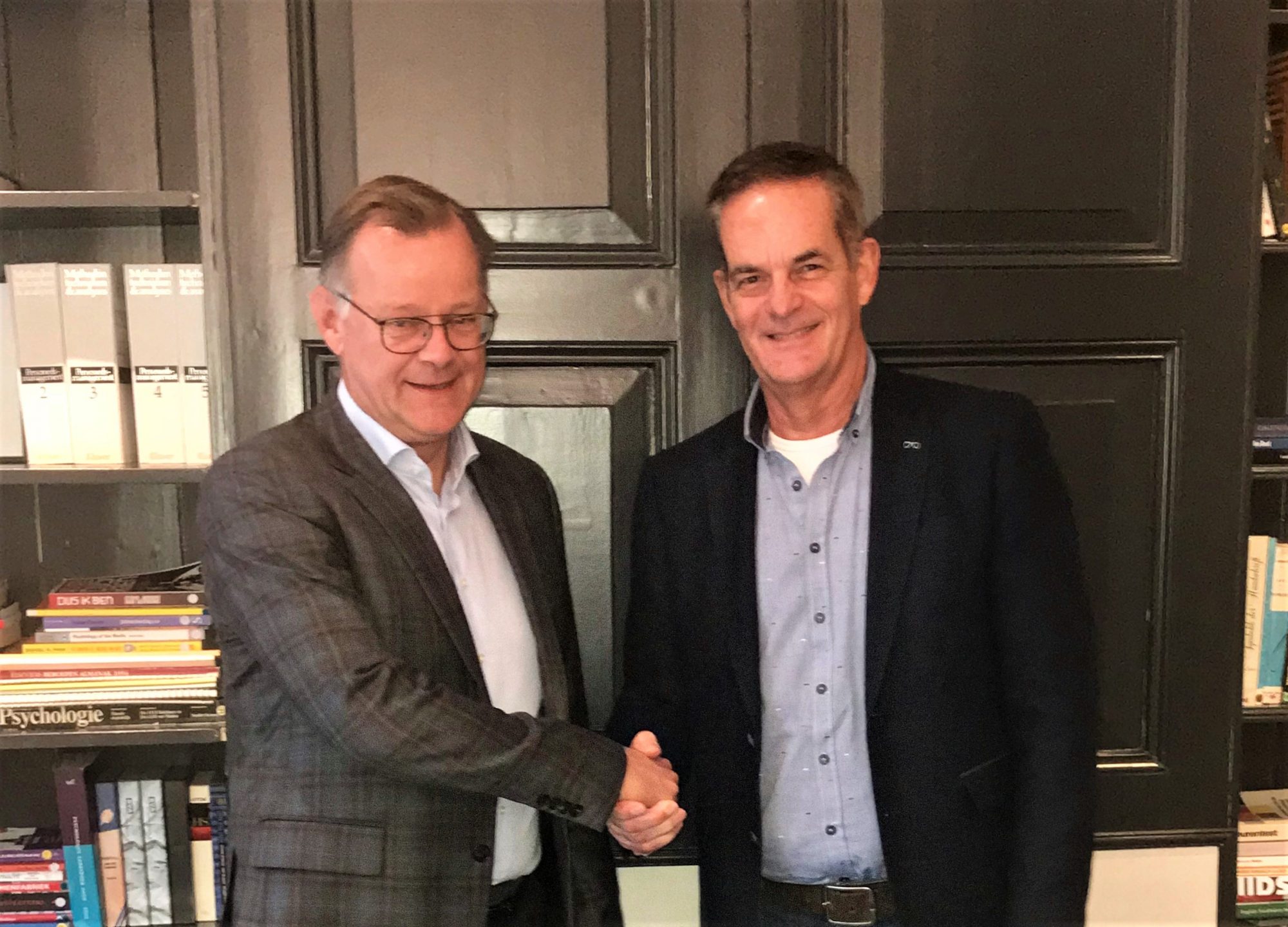 Marco ten Berge (links), directeur van St. Communicatie en Miel in 't Zand, directeur van st. Topsport for Life, schudden elkaar de hand op de nieuwe samenwerking.